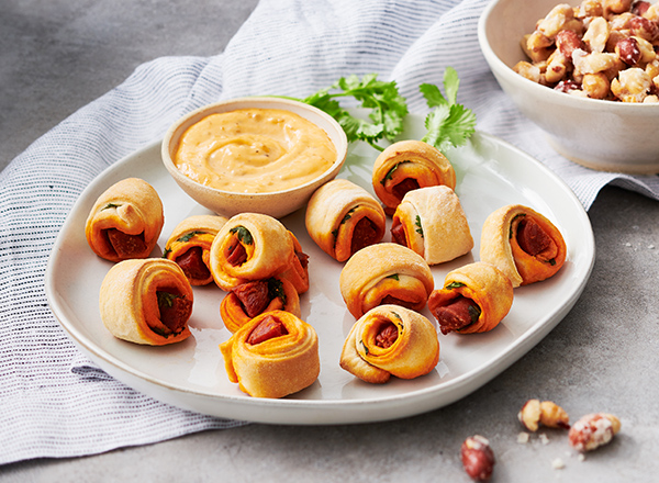 Chorizo Pigs in a Blanket with Sofrito-Truffle Mayo and Candied Chili-Garlic Peanuts