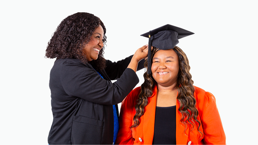 Jamyiah S.C. Teasley having a graduation cap placed on her head by her mother.