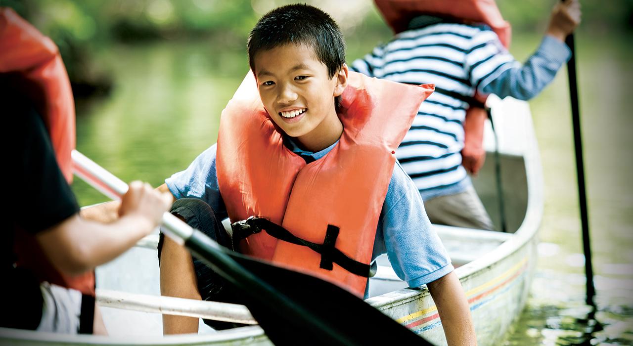 youth boy smiles in a canoe