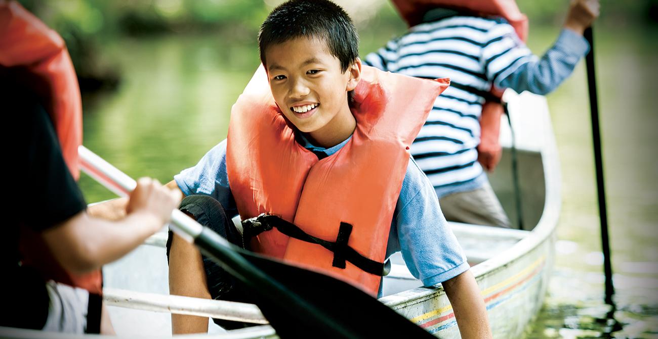youth boy smiles in a canoe