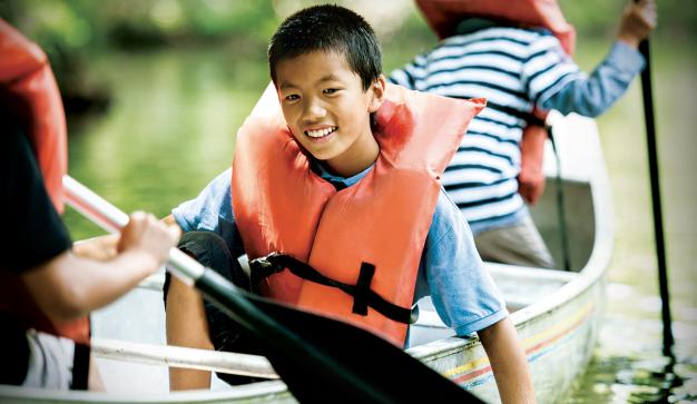 youth boy smiles in a canoe