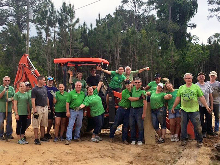 publix serves work team smiling while standing on a red tractor parked in clay