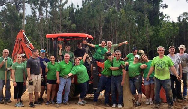 publix serves work team smiling while standing on a red tractor parked in clay