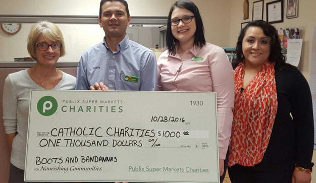 public charities presents check donation to catholic charities
