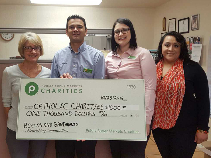 public charities presents check donation to catholic charities