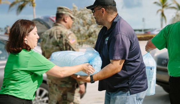 publix associate giving large bag of ice to american red cross irma relief efforts