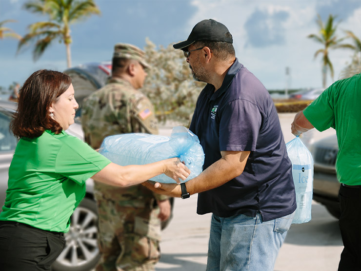 publix associate giving large bag of ice to american red cross irma relief efforts