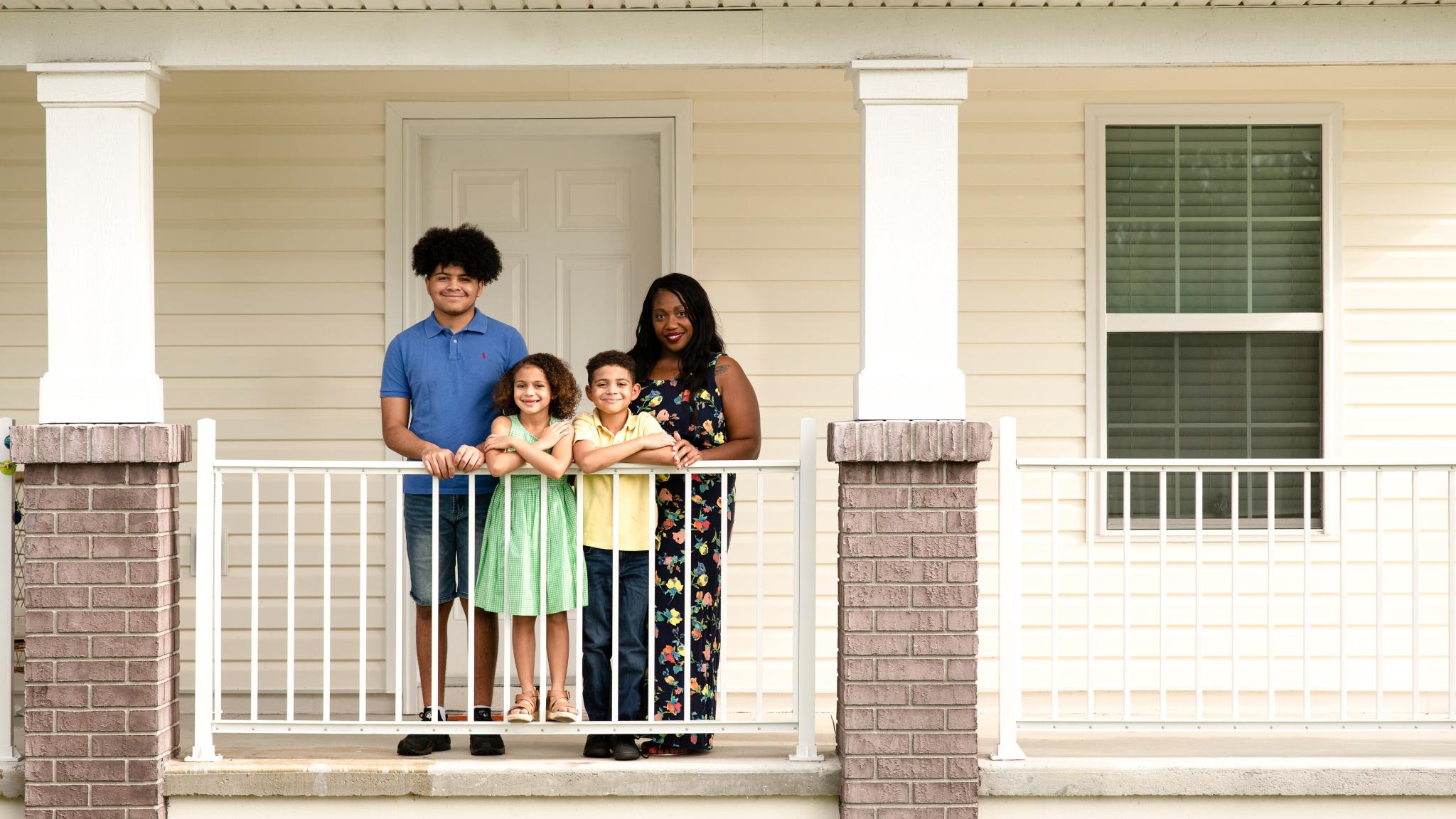 family standing in front of a house