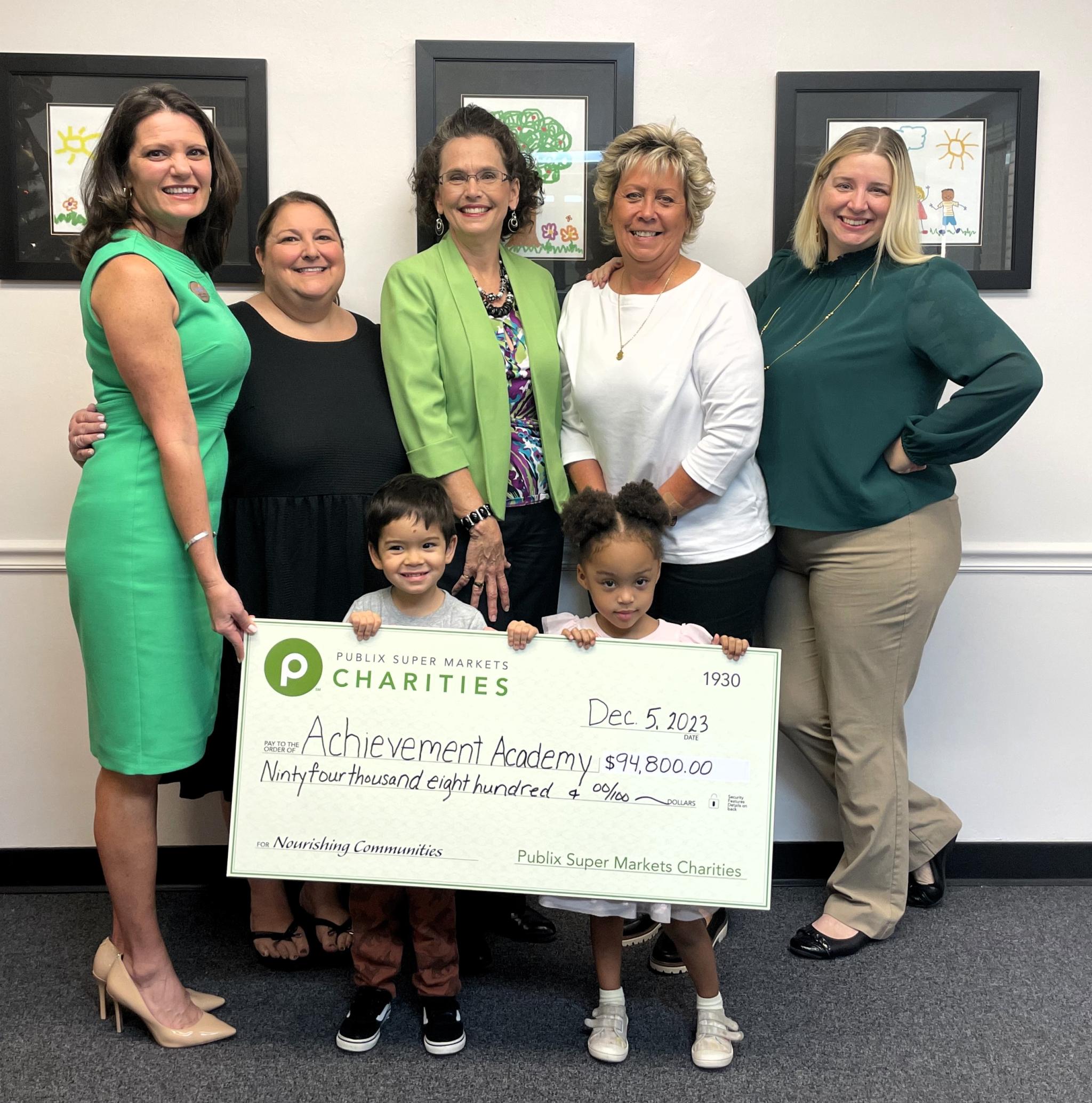 Group of people holding a large check