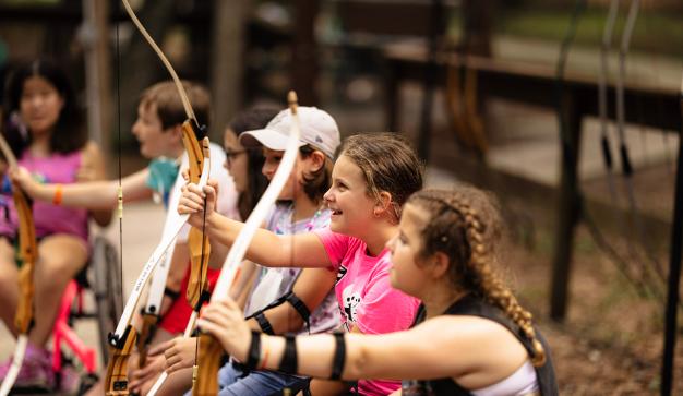 kids trying archery at camp boggy creek