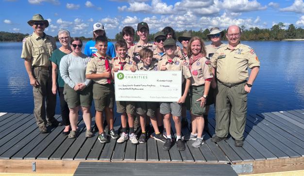 Boy Scouts of America posing with large check to support Camp Flaming Arrow
