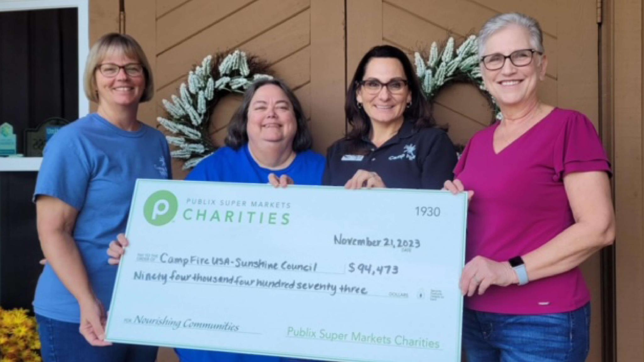 group of people holding a large charity check