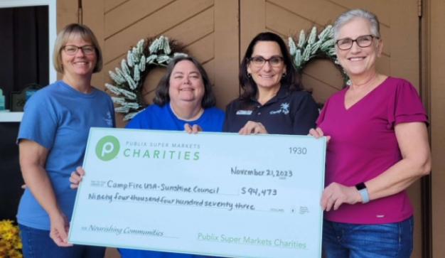 group of people holding a large charity check