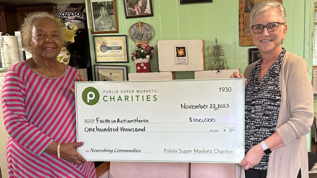 two people holding charity checks