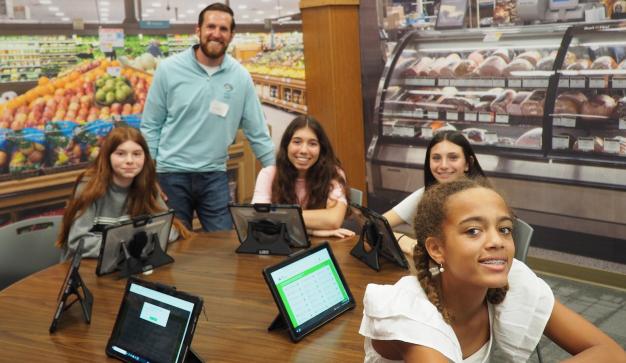 kids in a Publix super market with tablets