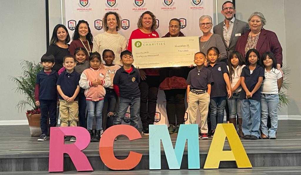 Group of kids holding a check for Redlands Christian Migrant Association