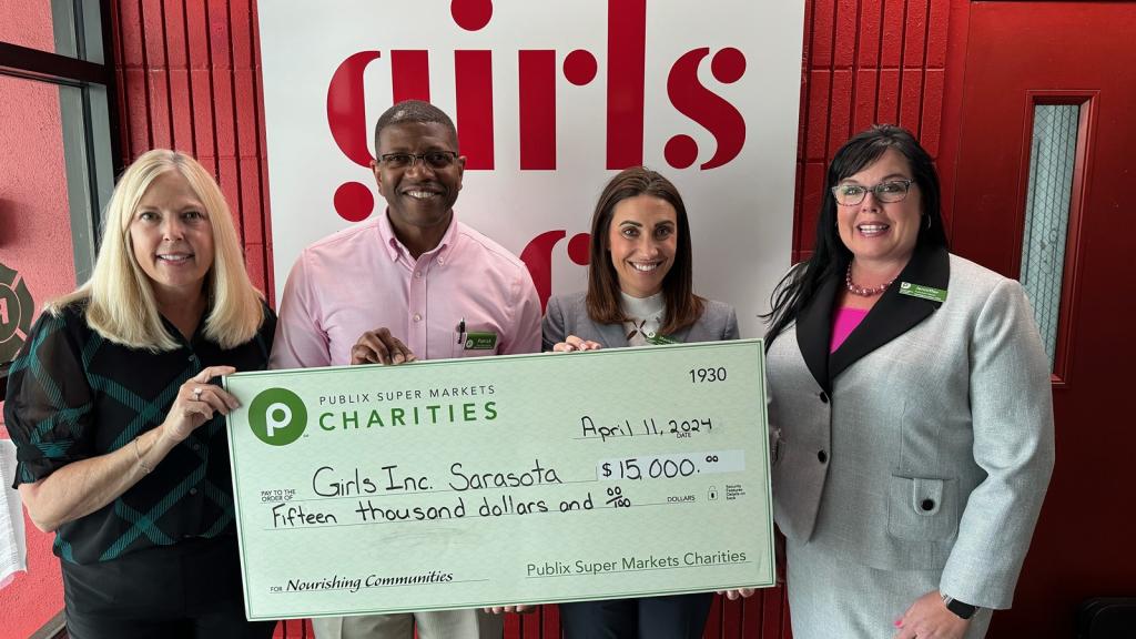 group holding a large charity check for Girls inc of Sarasota