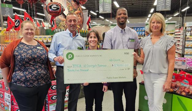 Publix associate presenting a giant charity check