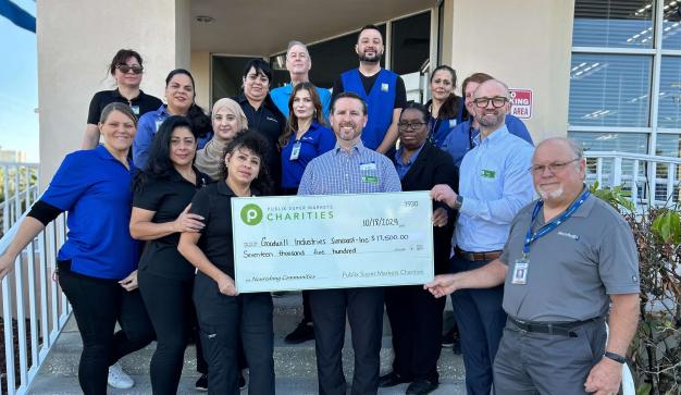 presenting a giant charity check to Goodwill