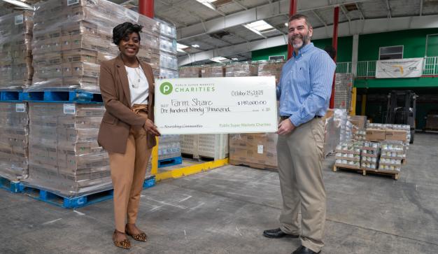 presenting a giant charity check to Farm Share