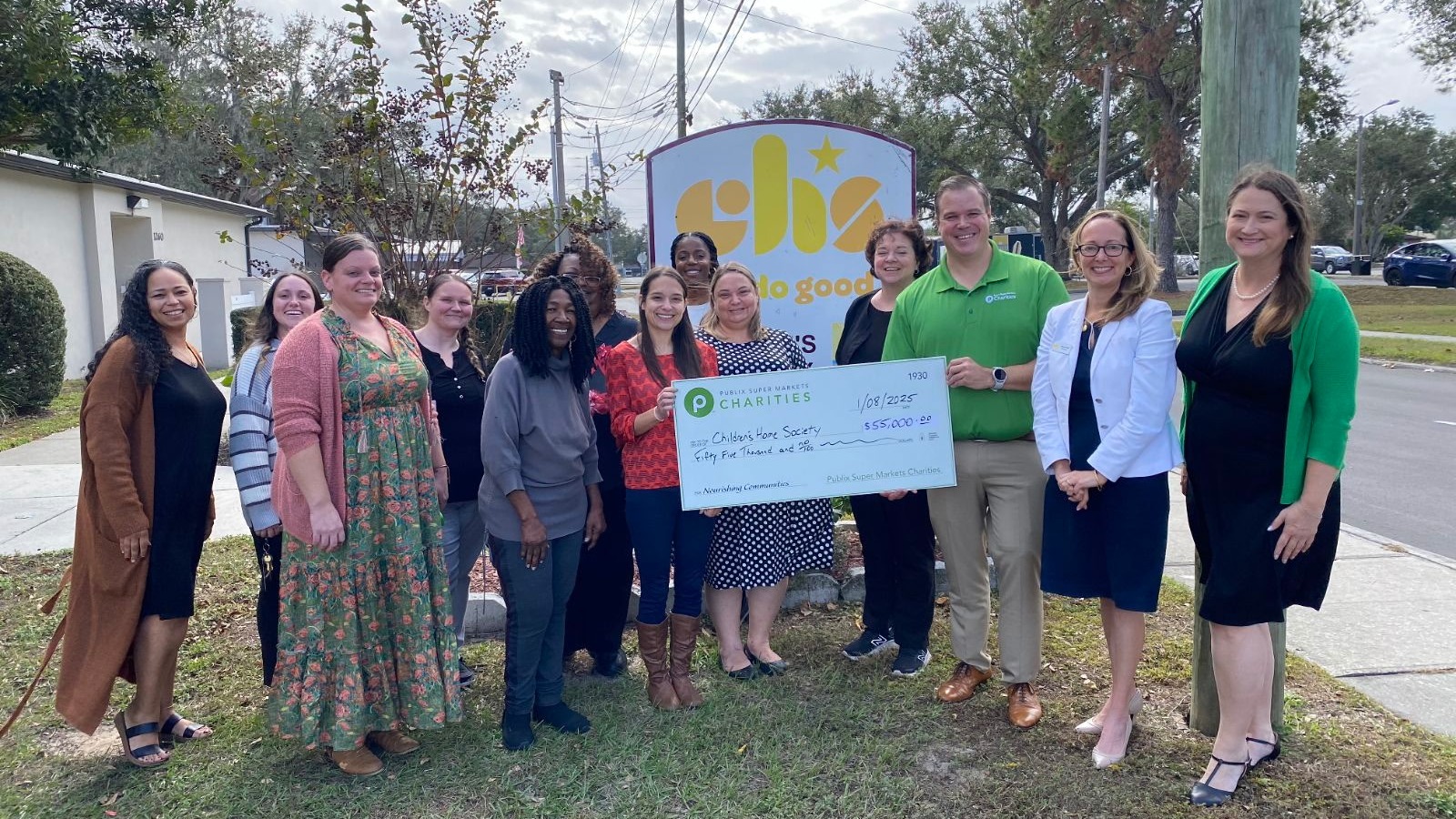 Group holding a charity check outside the Children’s Home Society