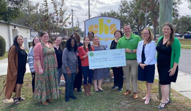 Group holding a charity check for $55,000 outside the Children’s Home Society