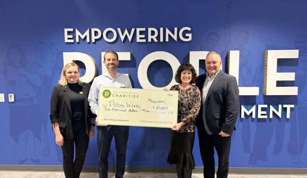 Four people holding a $10,000 charity check for Nobis Works