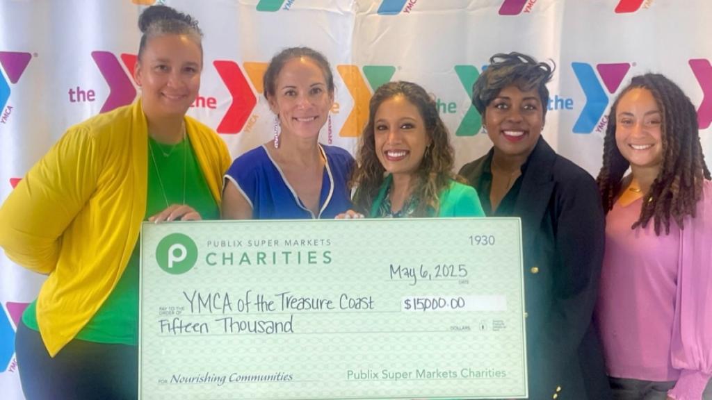 five women holding a charity check made out to the YMCA of the Treasure Coast