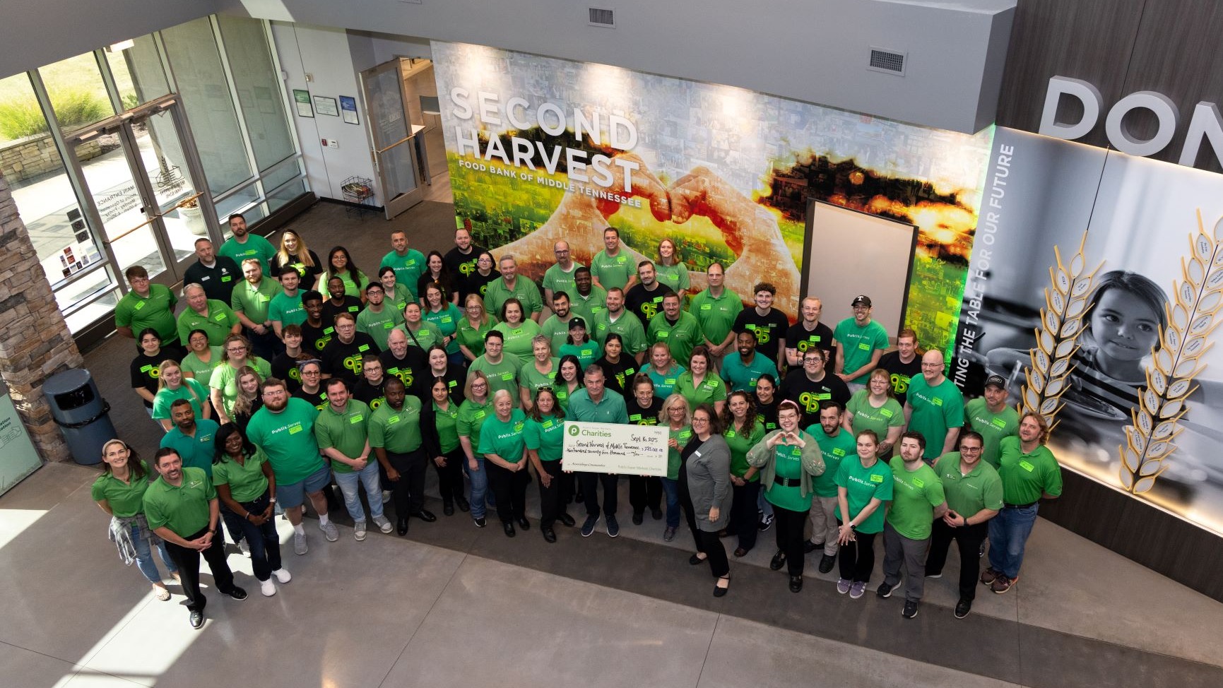 Group volunteers holding a cahrity Check at Second Harvest Food bank