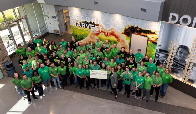 Group volunteers holding a cahrity Check at Second Harvest Food bank