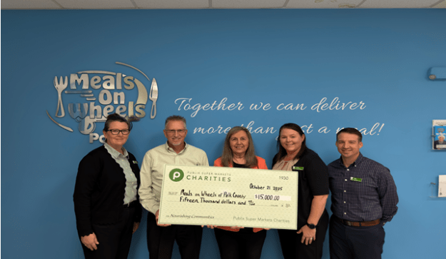 Meals on Wheels team accepting a giant charity check