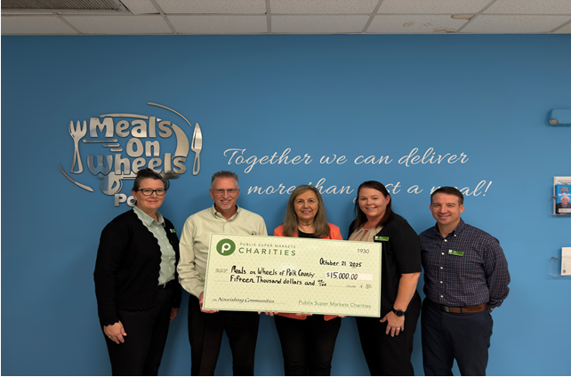Meals on Wheels team accepting a giant charity check