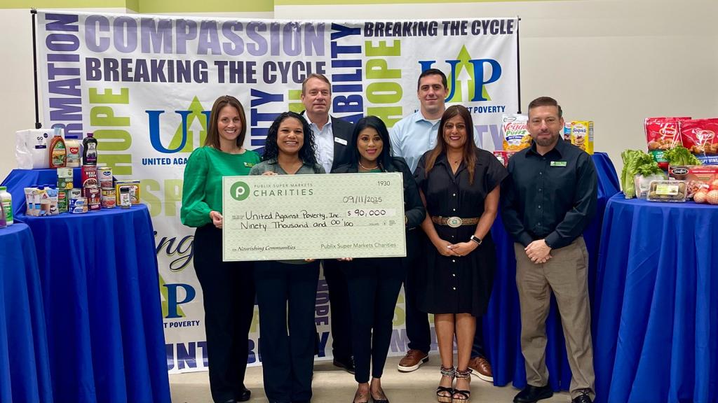 Team holding a giant charity check for United Against Poverty