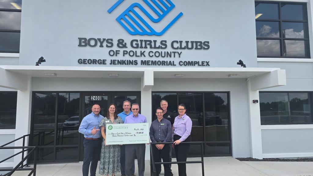 Publix Charities representatives present a $30,000 donation check to Boys & Girls Clubs of Polk County outside its facility.