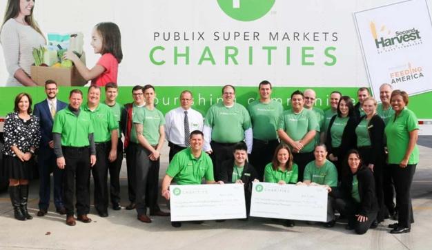 group holding giant checks in front of a Publix Super Market Charities sign