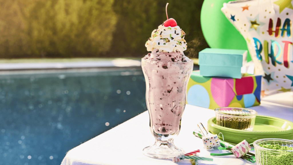 milkshake and birthday party supplies by a pool