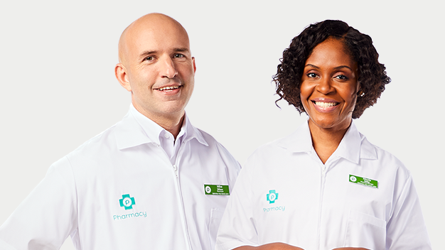 Man and woman wearing pharmacy white coats smiling