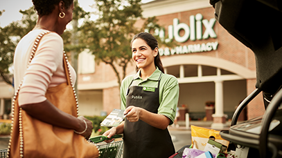 publix associate helping customer to car in front of store