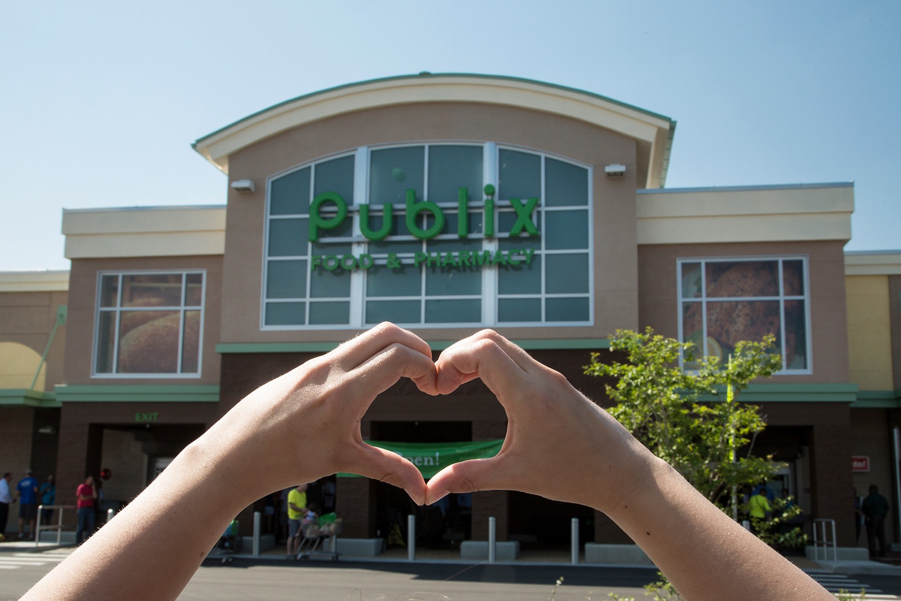 hands making a heart infront of a publix store