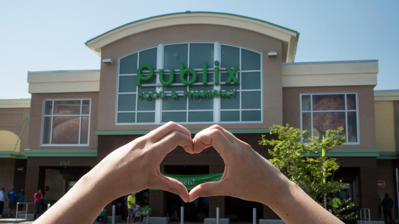 hands making a heart infront of a publix store