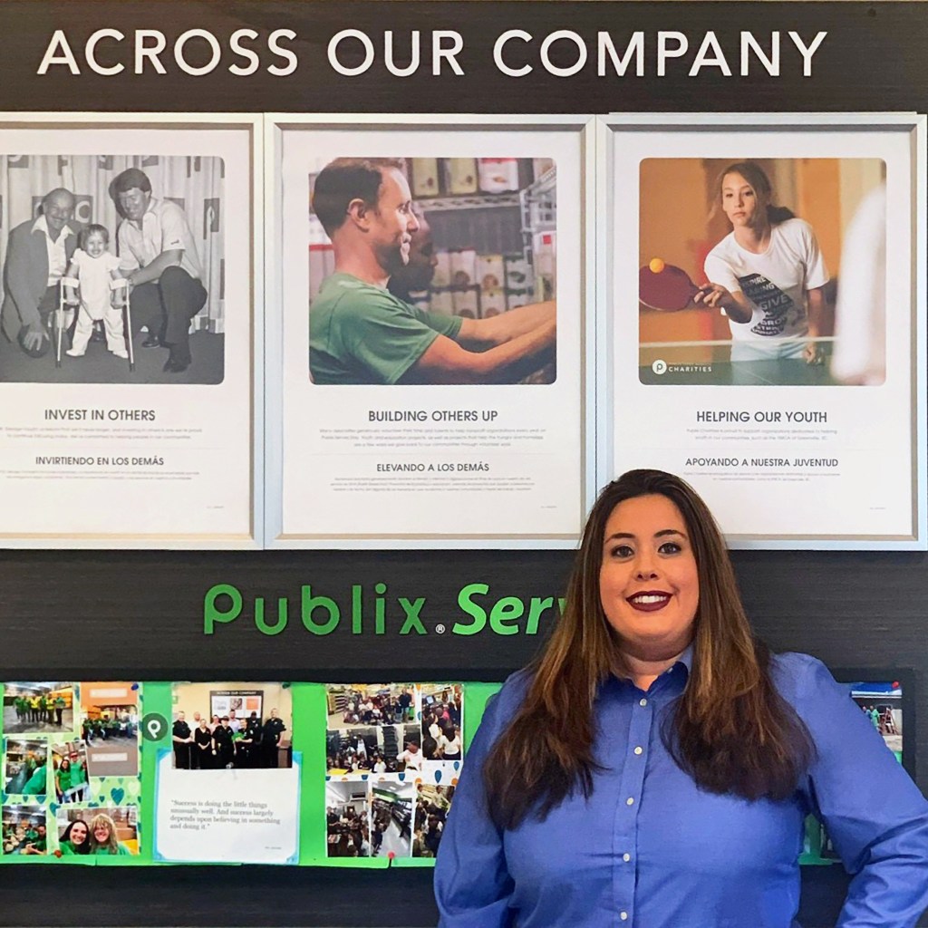 Vivian in front of a publix serves sign