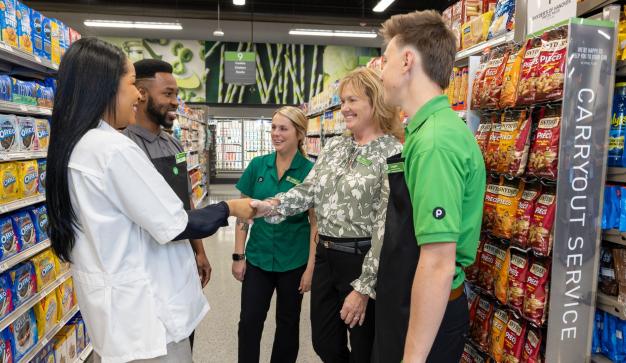 A group of publix associates meeting to improve well-being in a Publix store