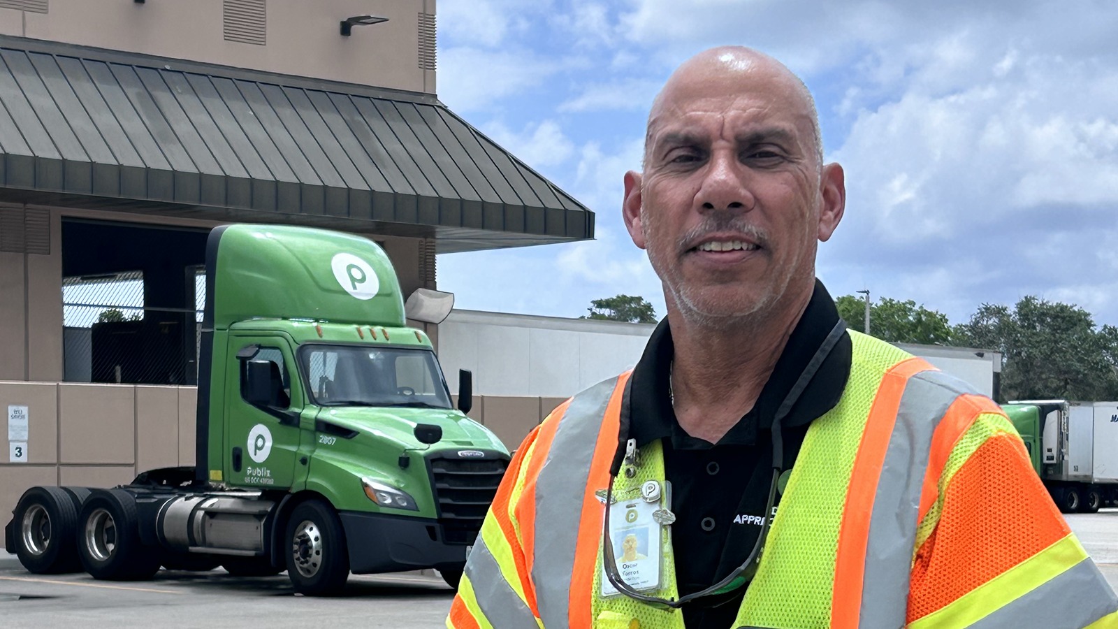 Oscar wearing a safety vest in front of a Publix truck