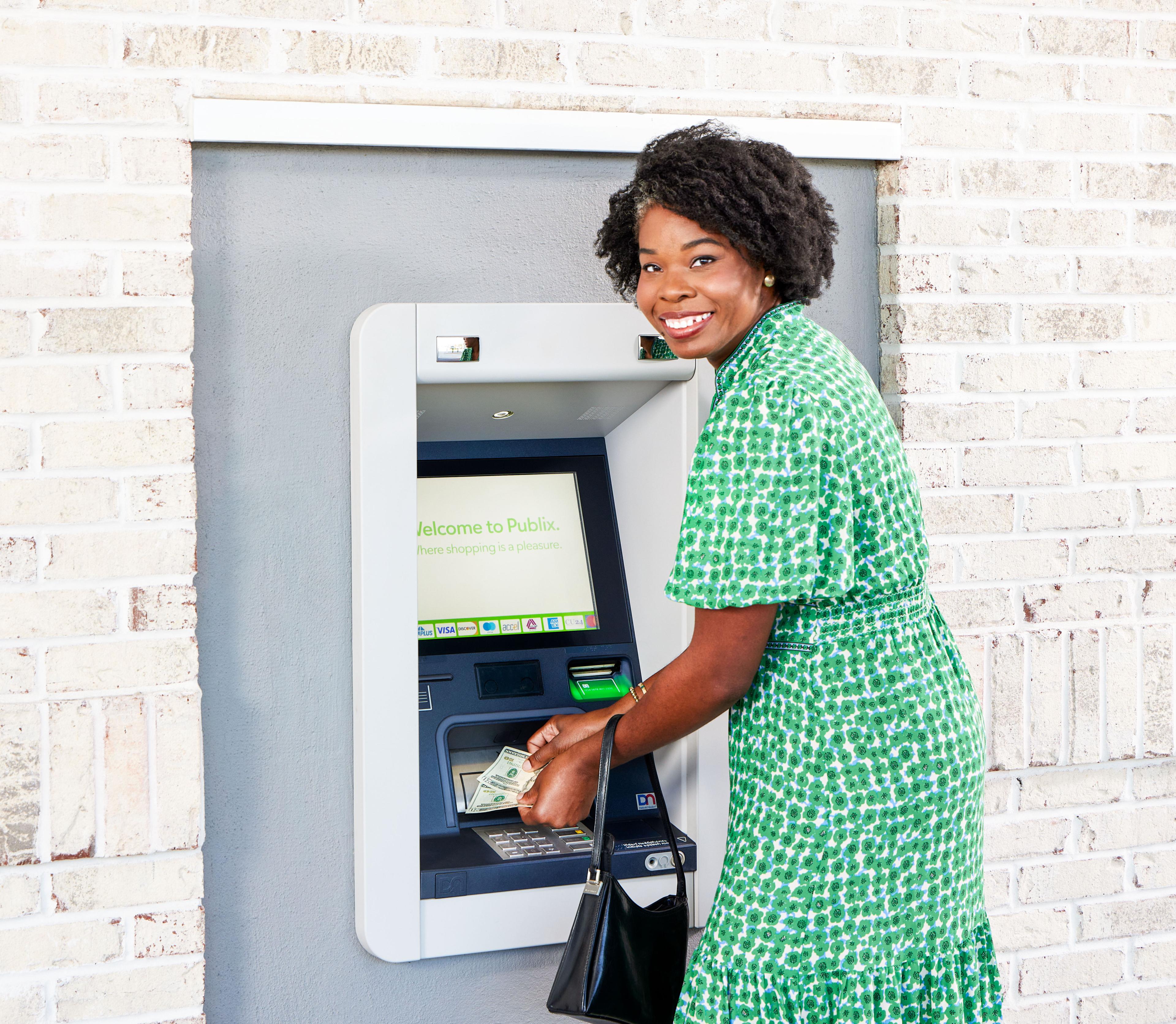Women getting cash out of a Presto ATM at Publix