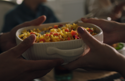 hands passing a dish of food