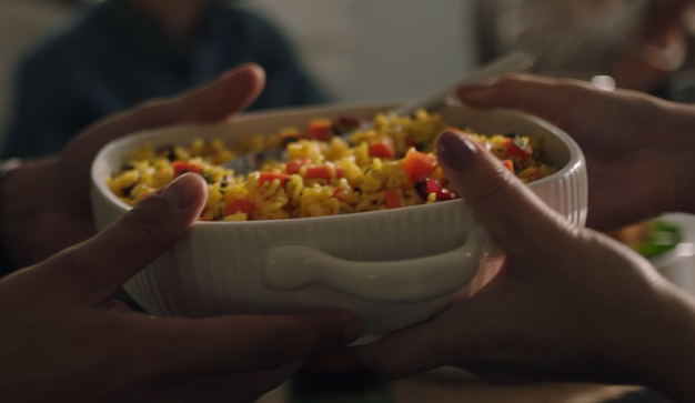 hands passing a plate of food