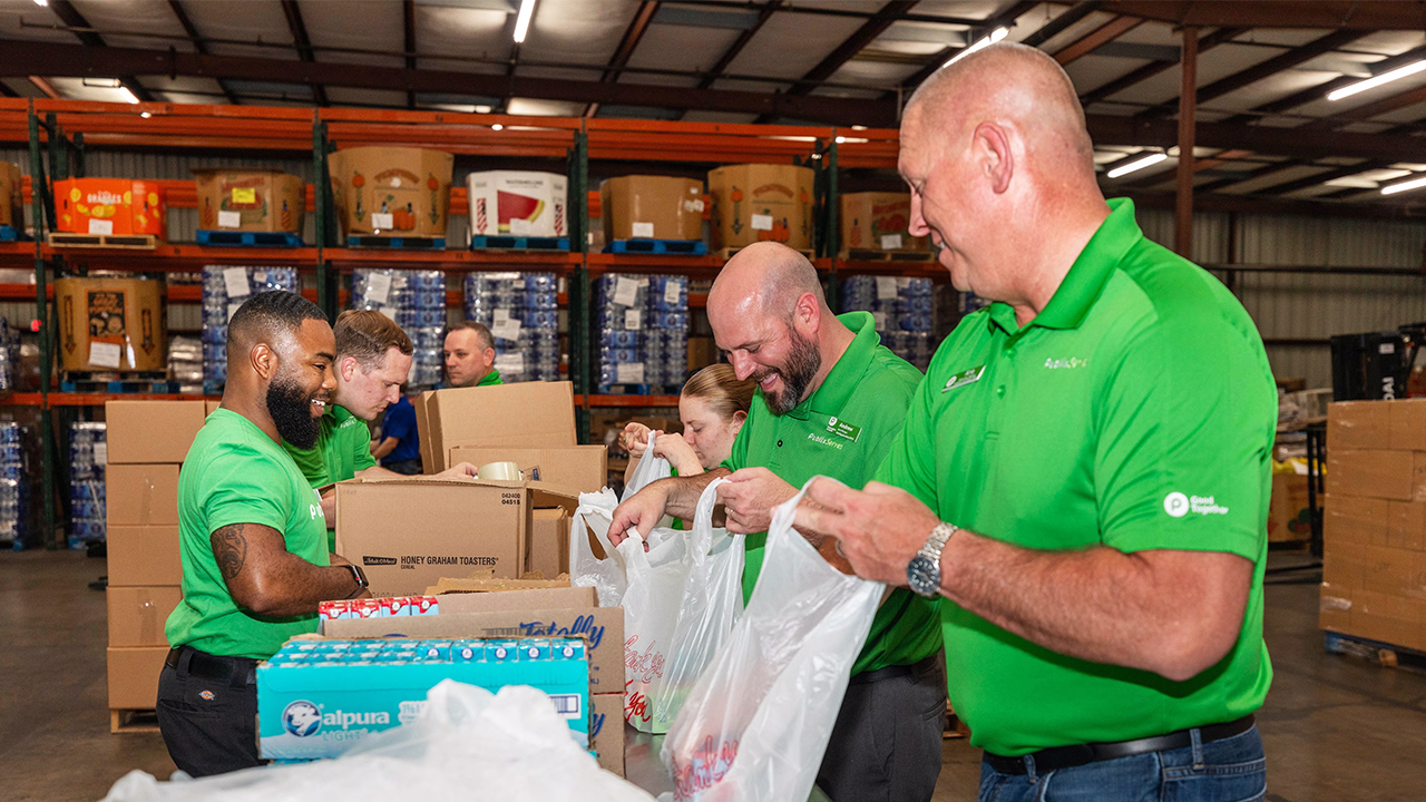 Publix associates helping bag groceries at a food bank
