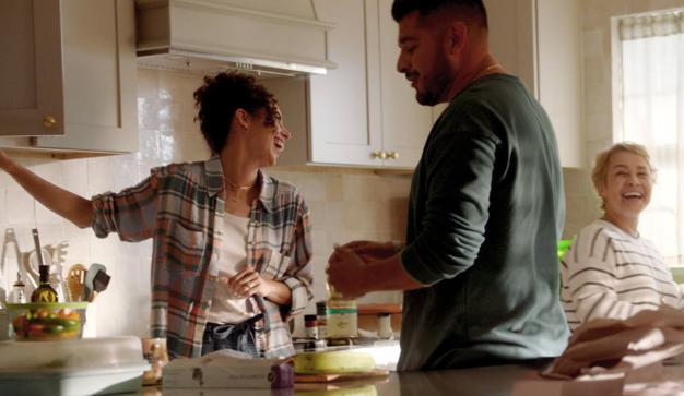 Family laughing while they cook together