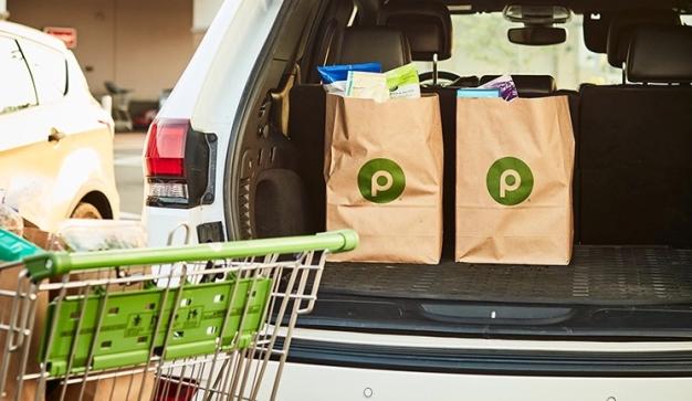 Publix bags being loaded into the back of a car