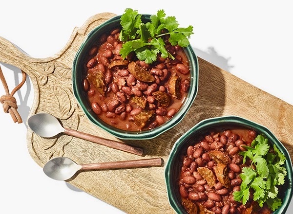 two bowl of red beans on a decorative carved wooden board